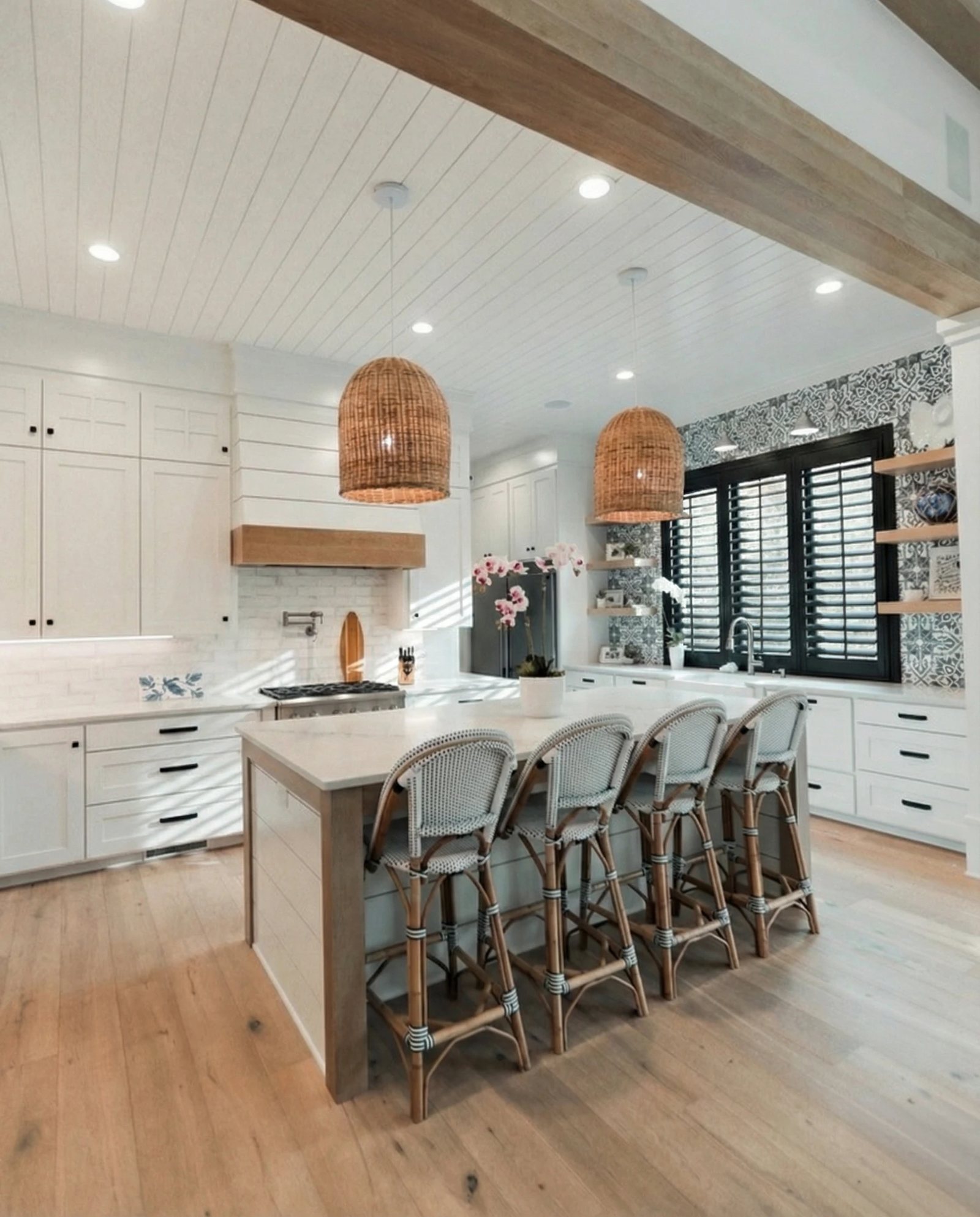 Black custom plantation shutters in a Modern Farmhouse kitchen with shiplap ceiling and exposed beam